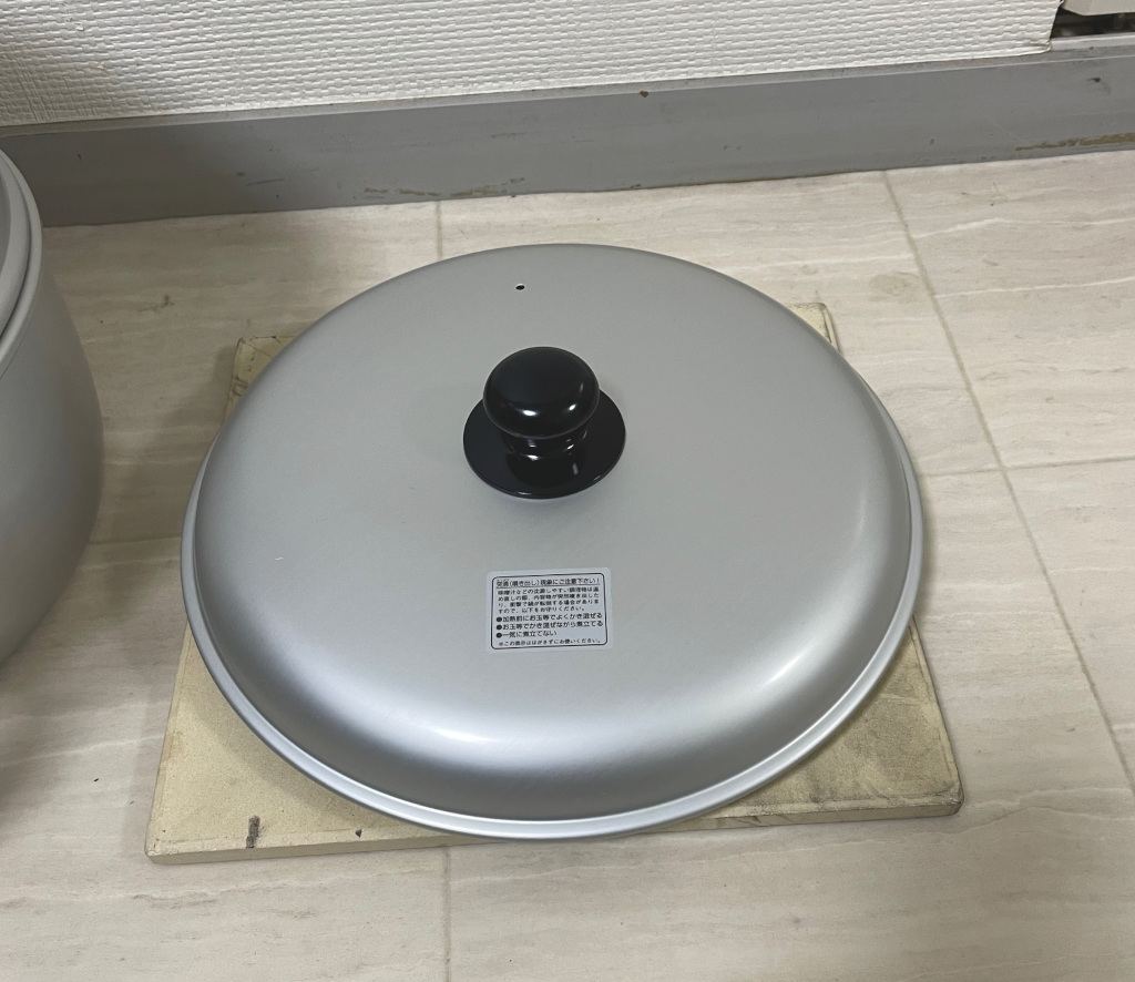 ホーロー製の鍋のフタとピザストーン